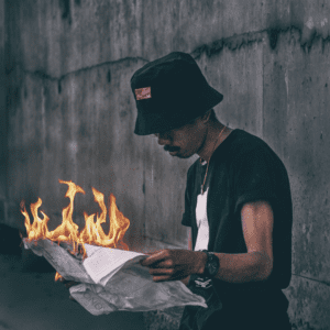 Person reading a newspaper that is on fire